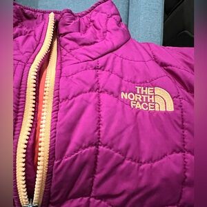 The North Face Woman's light Quilted Jacket with Yellow color zipper.